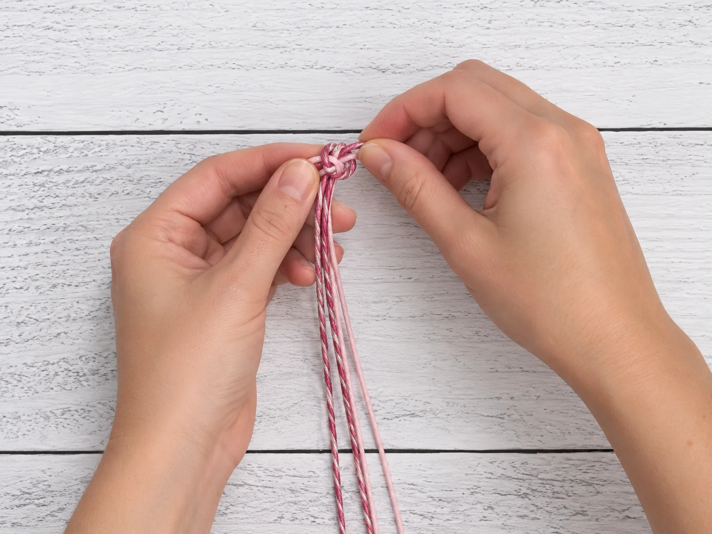 Step 1 tying the four hemp cords together with an overhand knot
