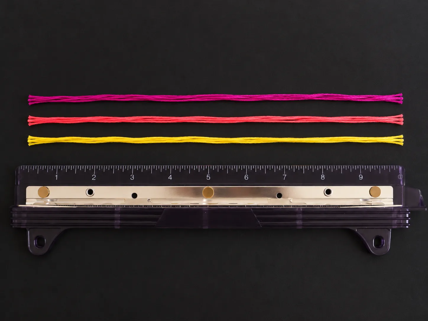 Measuring and cutting three colors of embroidery floss for a spiral friendship bracelet