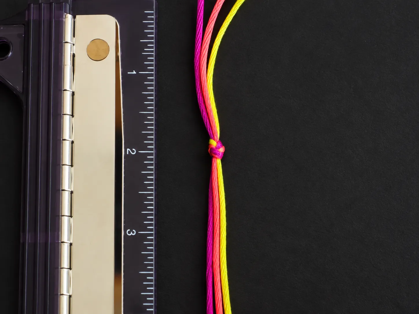 Three embroidery floss strands tied together with a starting knot for a spiral friendship bracelet