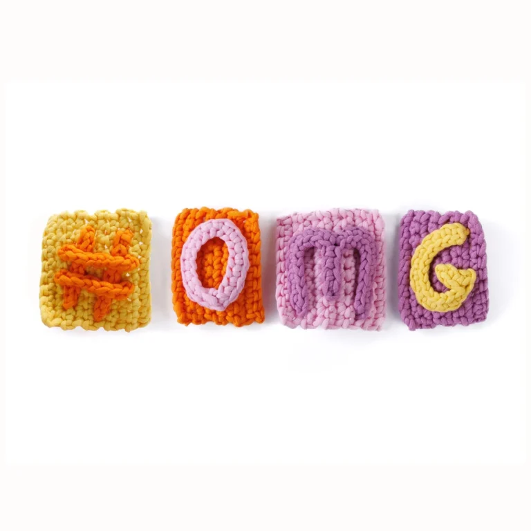 Colorful crochet letter bag charms displayed on a table