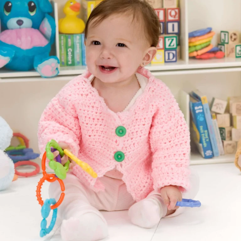 Crochet baby sweater in pastel colors designed with the Little Blossom pattern